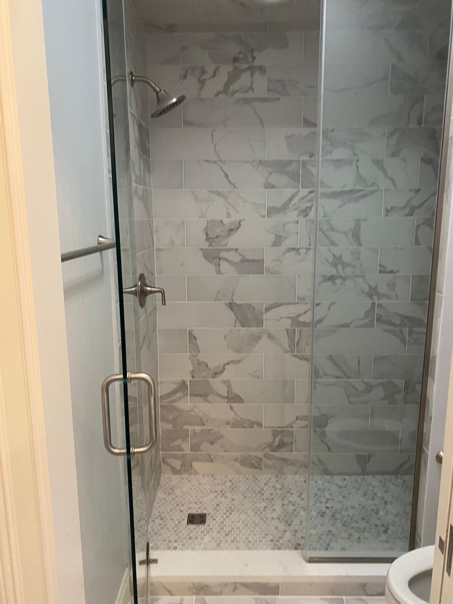 Marble look tile walk-in shower with glass door
