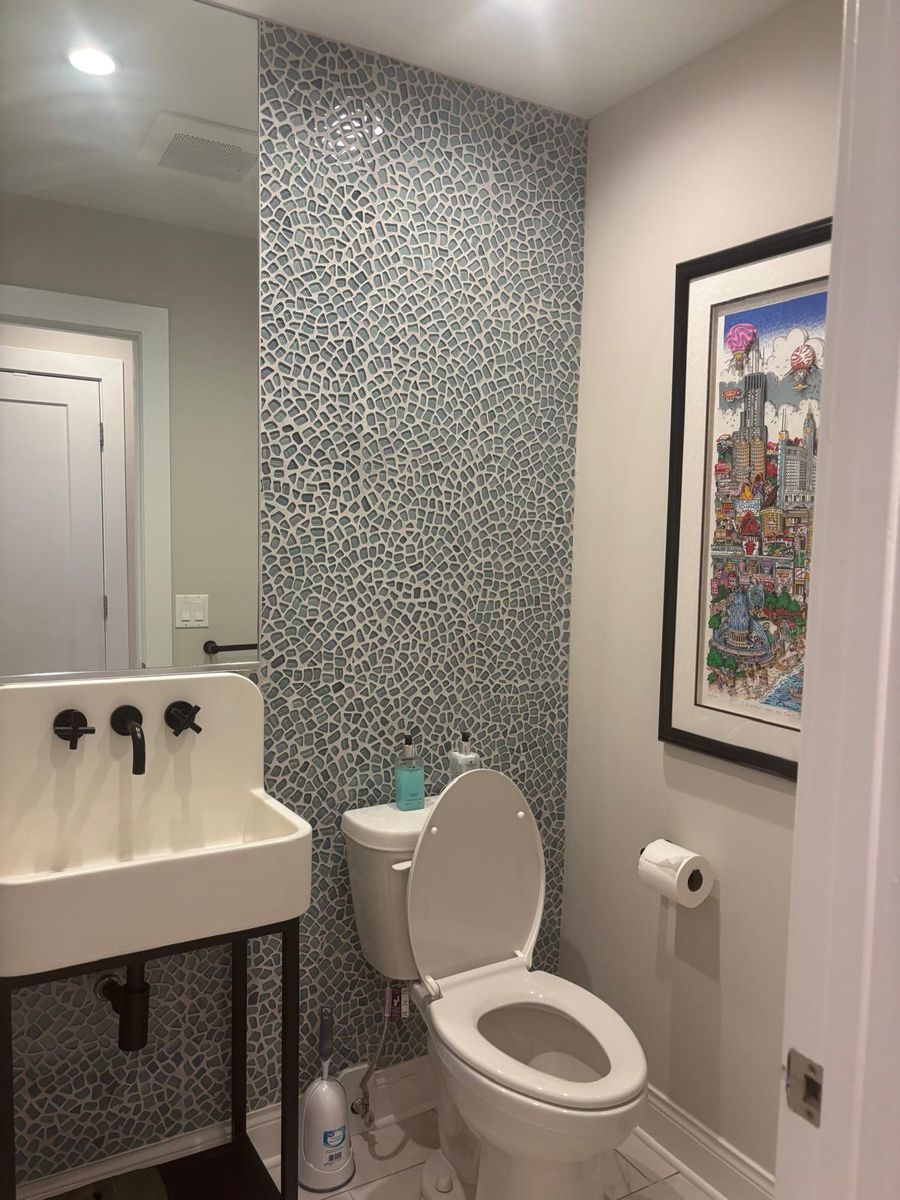 Powder room with a pebble tile accent wall